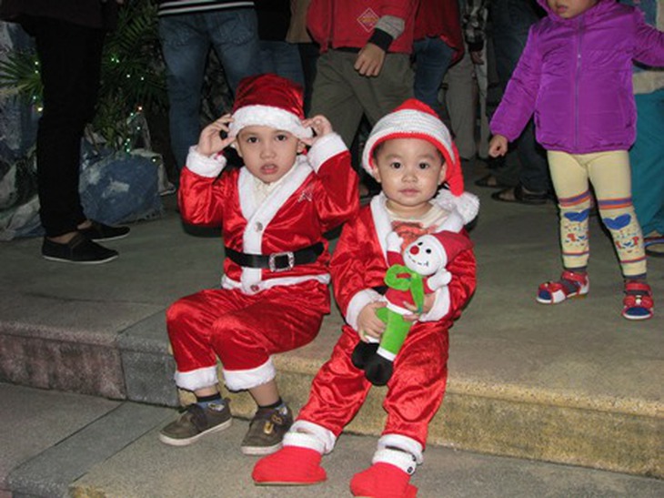 Hai em nhỏ được bố mẹ cho đi chơi Noel