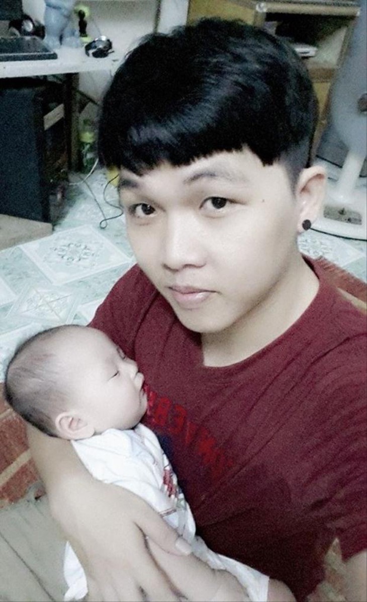 Đứa con trai dễ thương trong vòng tay của anh Đức. 