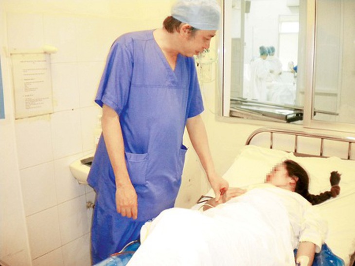 TS. Vũ Bá Quyết, Giám đốc Bệnh viện Phụ sản TW thăm khám cho bệnh nhân Đ.T.M. Ảnh: Thái Bình