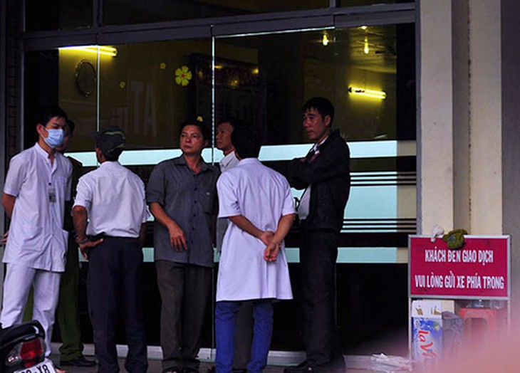 Cảnh sát cùng nhân viên y tế trước cửa ngân hàng. Ảnh: Thái Hà