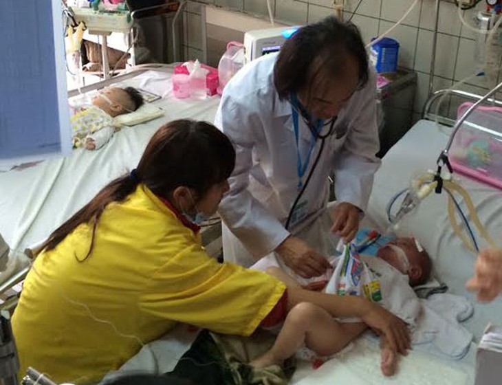 PGS.TS Nguyễn Tiến Dũng khám cho một bệnh nhi viêm nặng. 