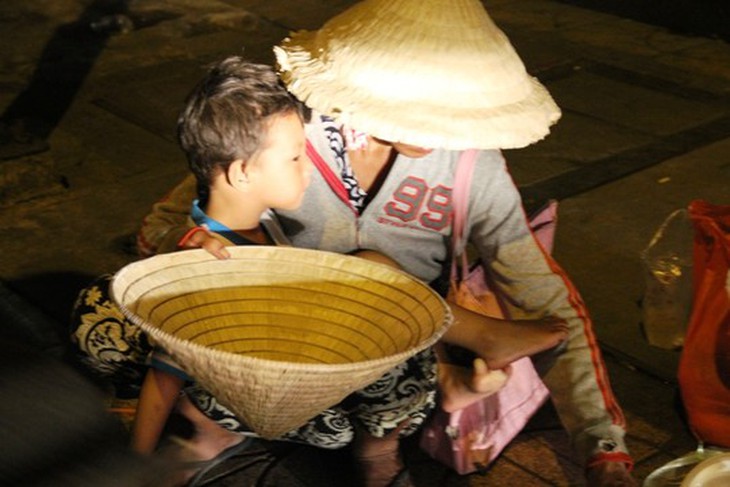 Cảnh người phụ nữ bồng bế trẻ em lao ra đường để xin tiền.