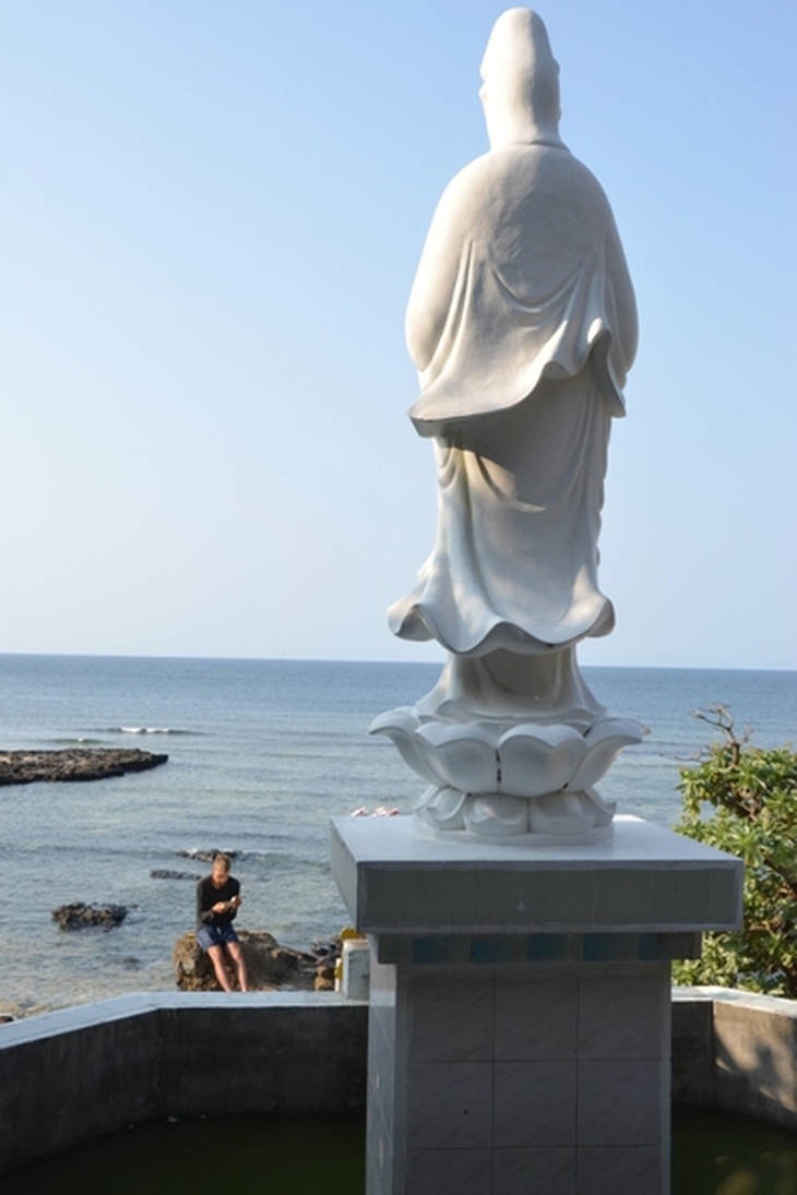 Nhiều du khách nước ngoài thích đọc sách trước tượng Phật quan âm ở chùa Hang.