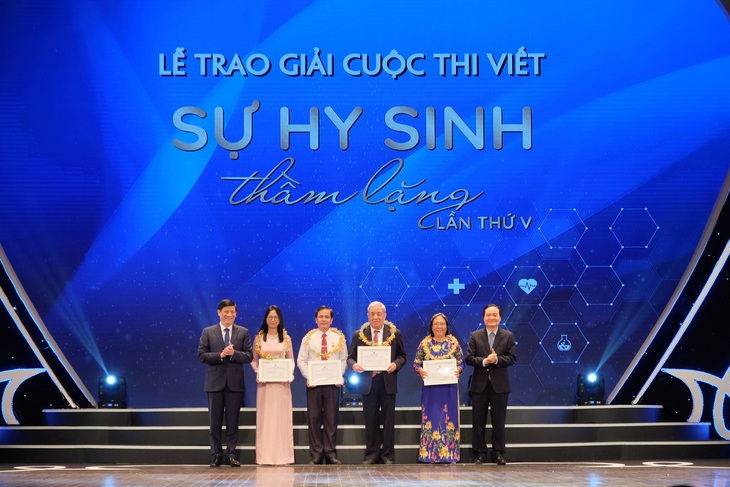 GS. TS. Nguyễn Thanh Long - Bộ trưởng Bộ Y tế (bên trái ảnh) trao giải cho một số tác giả đoạt giải Cuộc thi viết "Sự hy sinh thầm lặng" lần thứ V (năm 2020). Ảnh: Trần Minh
