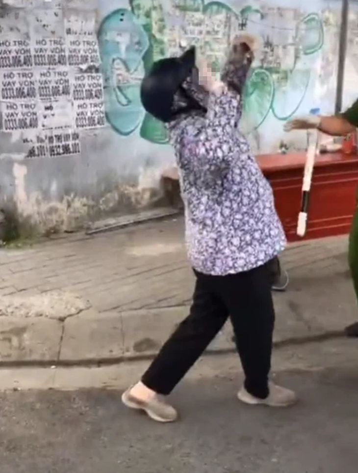 Vi phạm giãn cách xã hội, người phụ nữ lăn ra đất ăn vạ đành đạch, cảnh