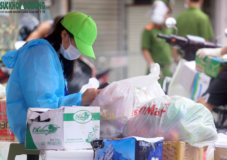[Ảnh] Người dân đội nắng, xếp hàng tiếp tế đồ vào khu vực phong tỏa tại Hà Nội - Ảnh 12.