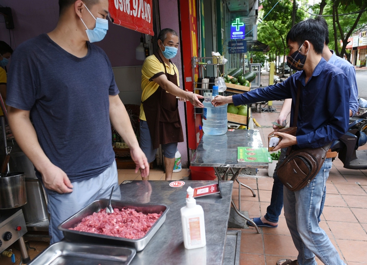 [Ảnh] Người Hà Nội xếp hàng mua phở, bún chả, sửa xe lúc 12h trưa tại 19 quận, huyện được nới lỏng - Ảnh 3.