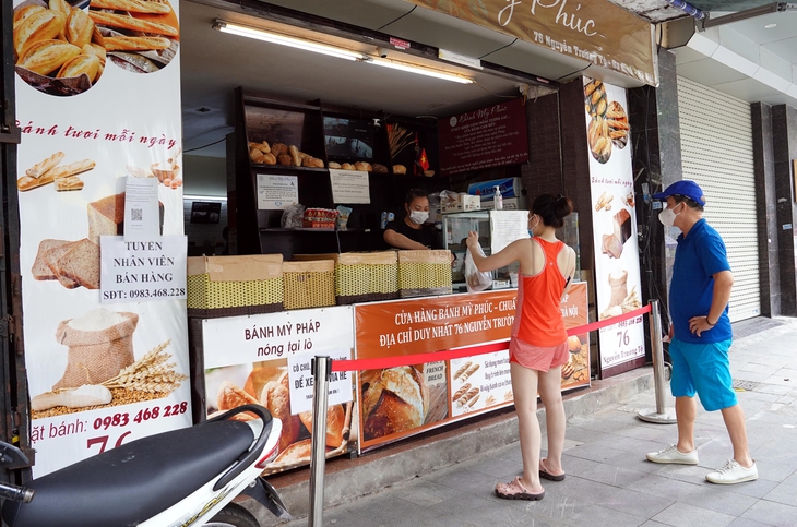 [Ảnh] Người Hà Nội xếp hàng mua phở, bún chả, sửa xe lúc 12h trưa tại 19 quận, huyện được nới lỏng - Ảnh 7.