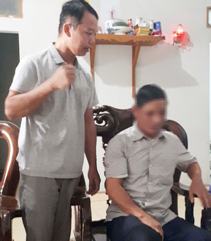 "Thầy lang" Hải (người đứng) đang khám chữa bệnh cho một bệnh nhân.