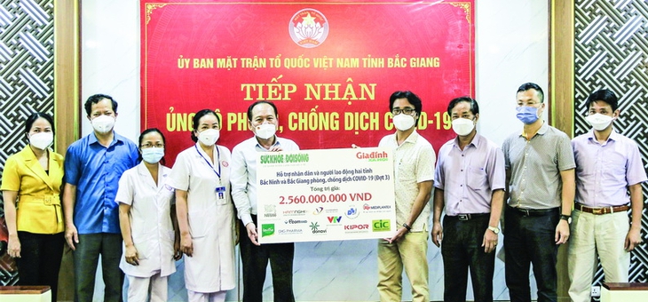 Ông Nguyễn Chí Long - Phó Tổng biên tập Báo Sức khỏe & Đời sống (thứ 4 từ phải sang) trao tặng quà hỗ trợ cho Ủy ban MTTQ Việt Nam tỉnh Bắc Giang. Ảnh: Kim Dung