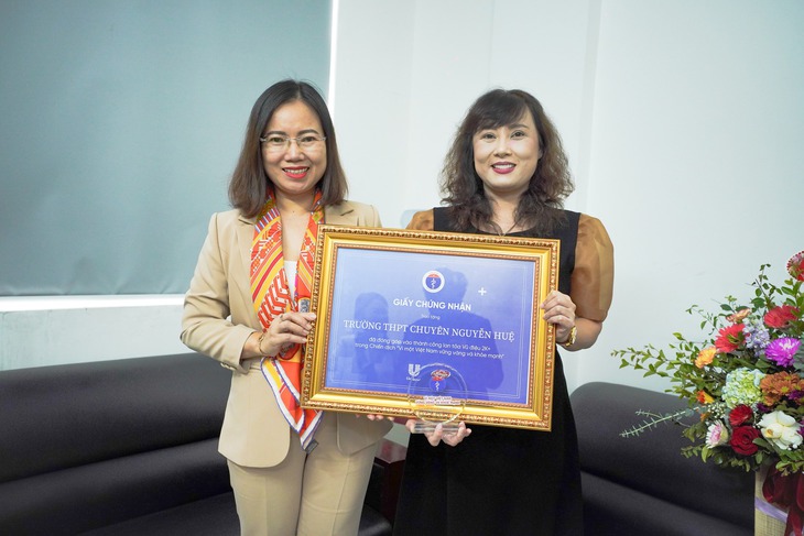 Bà Hoàng Thị Thơm - Phó Vụ trưởng Vụ Truyền thông và Thi đua, khen thưởng trao biểu trưng và giấy chứng nhận cho cô Phạm Thúy Hằng - Phó hiệu trưởng Trường PTTH chuyên Nguyễn Huệ - Hà Nội