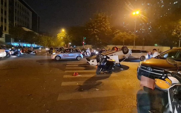 Ô tô phóng nhanh hất văng 2 người trên xe máy rồi lật ngửa giữa phố ở Hà Nội