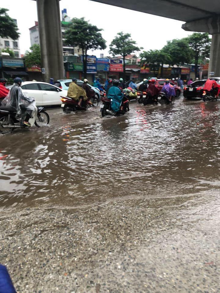 Mưa lớn kéo dài cả đêm, người dân Hà Nội đi làm trong "biển nước" - Ảnh 1.
