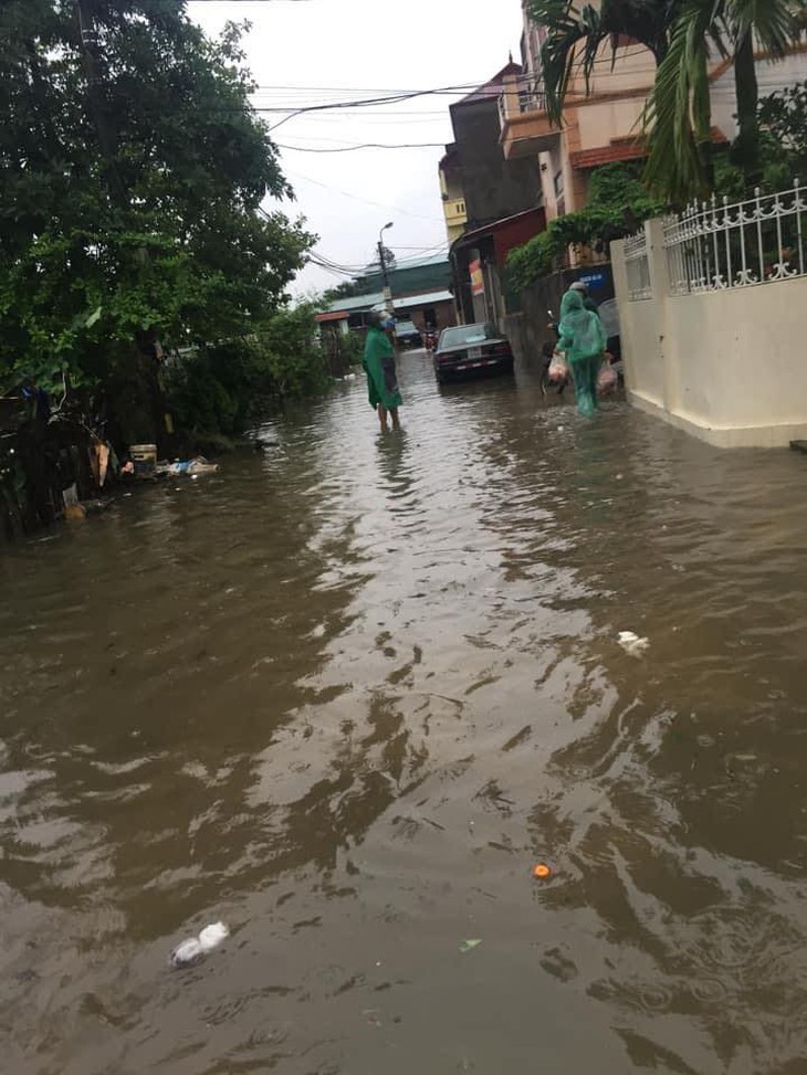 Mưa lớn kéo dài cả đêm, người dân Hà Nội đi làm trong "biển nước" - Ảnh 2.