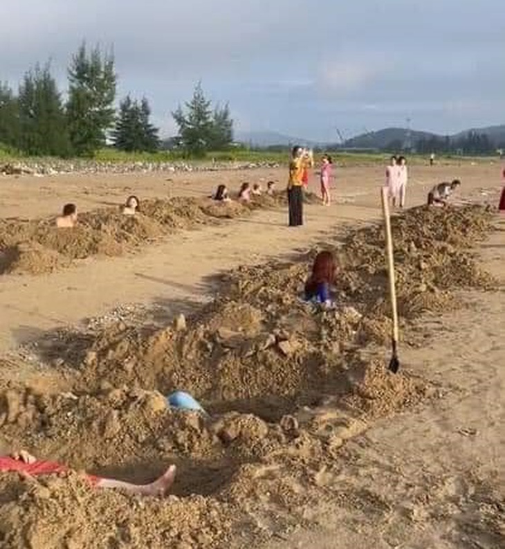 Xôn xao clip nhóm du khách đào nhiều hố trên bãi biển để "tắm cát" - Ảnh 1. Xôn xao clip nhóm du khách đào nhiều hố trên bãi biển để "tắm cát" - Ảnh 1.