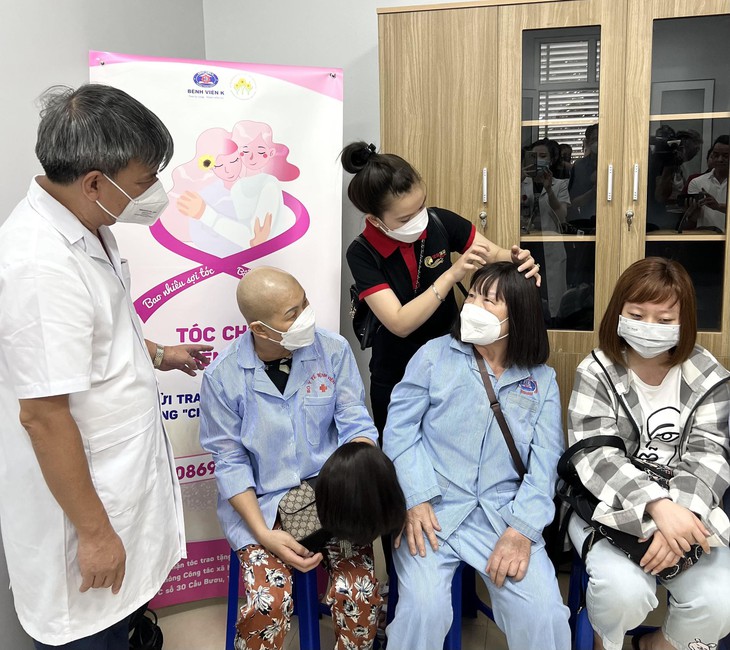 Xúc động hình ảnh những cô bé lên 10, cán bộ y tế và 'chiến binh ung thư' hiến mái tóc đen óng cho người bệnh - Ảnh 1.