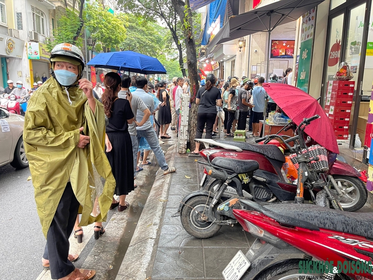 Người Hà Nội "đội mưa" xếp hàng dài mua bánh trung thu - Ảnh 2.