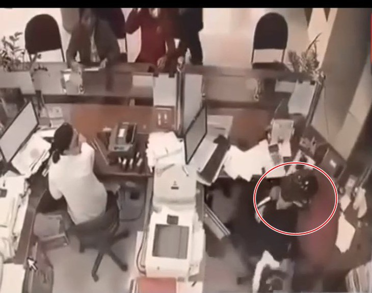 Video đối tượng xông vào ngân hàng khống chế nữ nhân viên để cướp- Ảnh 1.
