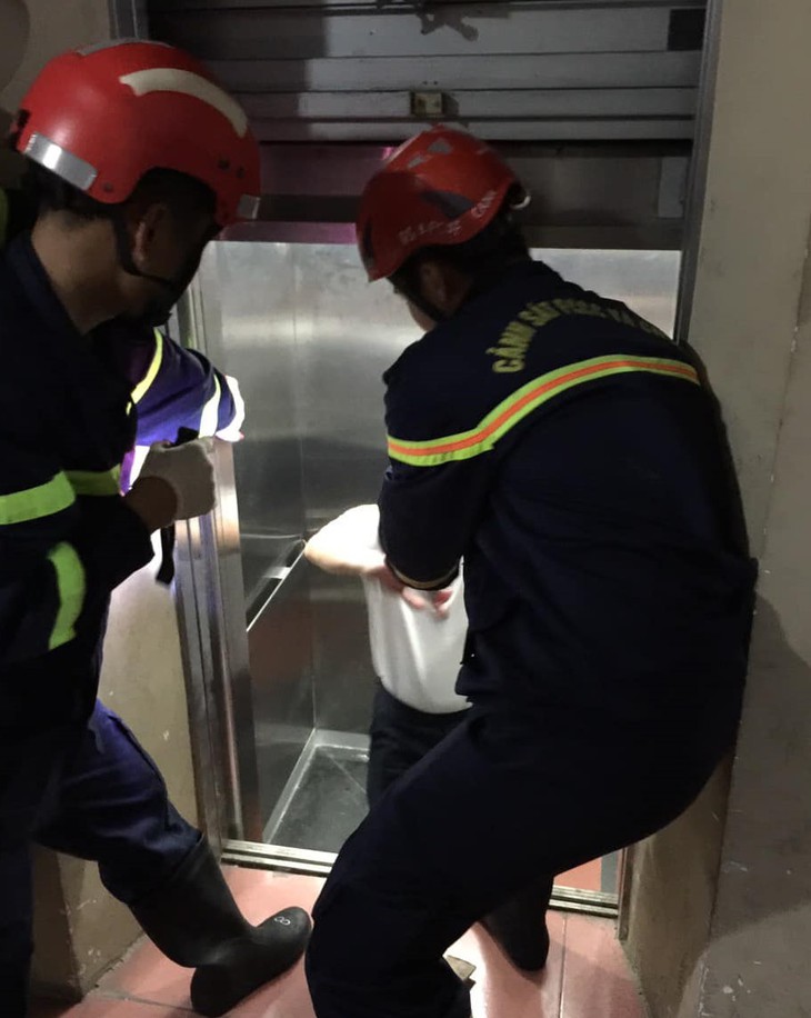 Nhanh chóng giải cứu 2 người mắc kẹt trong cầu thang máy - Ảnh 1.