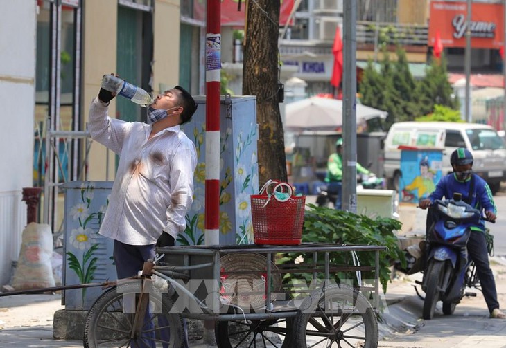 Mặt đường nóng rát hơn 50 độ C, người lao động Hà Nội “oằn mình" mưu sinh - Ảnh 13.