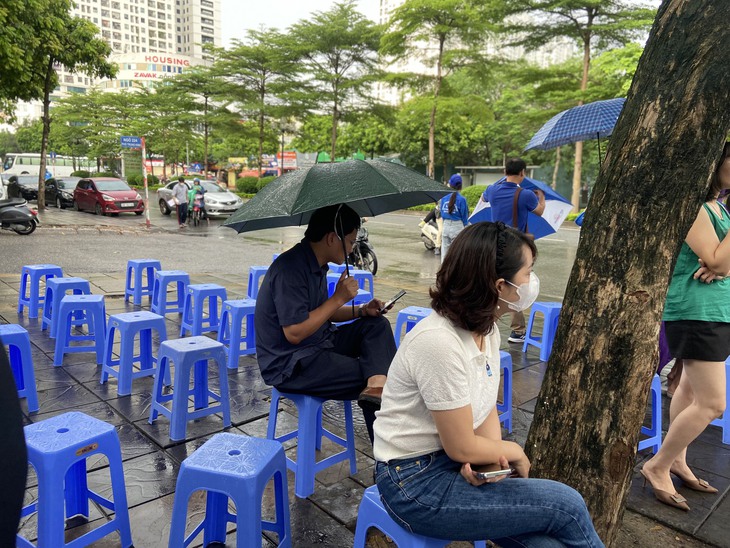 Phụ huynh lặng lẽ "dầm mưa" ngồi đợi con thi tốt nghiệp THPT - Ảnh 6. Phụ huynh lặng lẽ "dầm mưa" ngồi đợi con thi tốt nghiệp THPT - Ảnh 6.