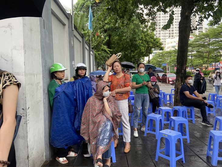 Phụ huynh lặng lẽ "dầm mưa" ngồi đợi con thi tốt nghiệp THPT - Ảnh 3. Phụ huynh lặng lẽ "dầm mưa" ngồi đợi con thi tốt nghiệp THPT - Ảnh 3.