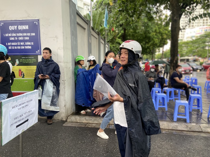 Phụ huynh lặng lẽ "dầm mưa" ngồi đợi con thi tốt nghiệp THPT - Ảnh 5. Phụ huynh lặng lẽ "dầm mưa" ngồi đợi con thi tốt nghiệp THPT - Ảnh 5.
