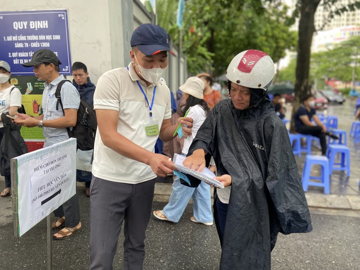 Phụ huynh lặng lẽ "dầm mưa" ngồi đợi con thi tốt nghiệp THPT - Ảnh 4. Phụ huynh lặng lẽ "dầm mưa" ngồi đợi con thi tốt nghiệp THPT - Ảnh 4.
