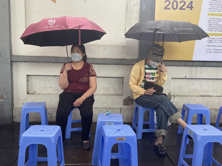 Phụ huynh lặng lẽ "dầm mưa" ngồi đợi con thi tốt nghiệp THPT - Ảnh 9. Phụ huynh lặng lẽ "dầm mưa" ngồi đợi con thi tốt nghiệp THPT - Ảnh 9.