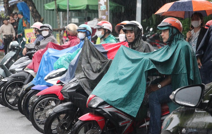 TP.HCM mưa lớn: Phụ huynh đứng dưới mưa chờ đón con thi tốt nghiệp THPT - Ảnh 2.