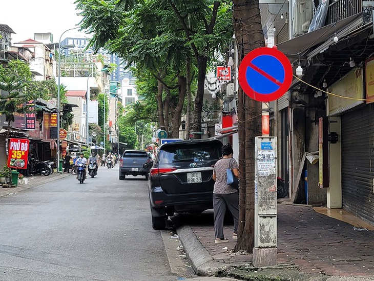 Hà Nội - Bất chấp biển cấm, ô tô vẫn đỗ tràn lan dưới lòng đường - Ảnh 8. Hà Nội - Bất chấp biển cấm, ô tô vẫn đỗ tràn lan dưới lòng đường - Ảnh 8.