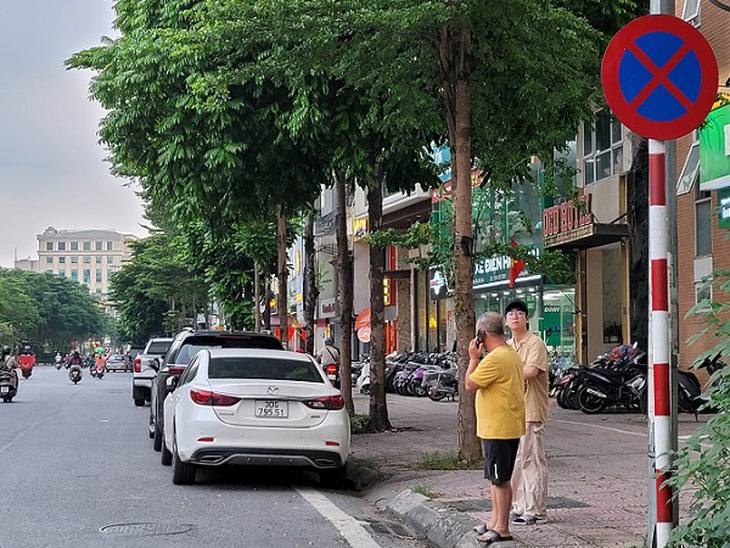 Hà Nội - Bất chấp biển cấm, ô tô vẫn đỗ tràn lan dưới lòng đường - Ảnh 10. Hà Nội - Bất chấp biển cấm, ô tô vẫn đỗ tràn lan dưới lòng đường - Ảnh 10.