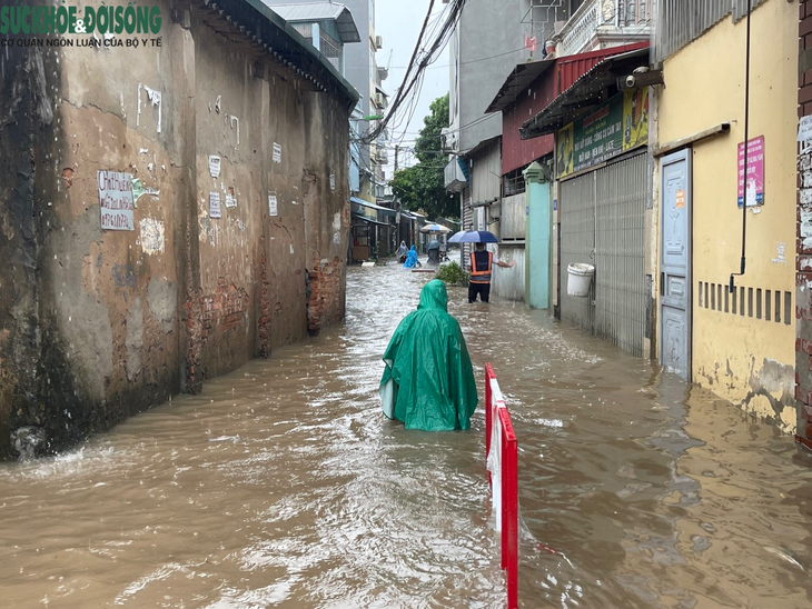 Đường phố Hà Nội ngập sâu sau mưa lớn, người dân chèo thuyền di chuyển - Ảnh 10.