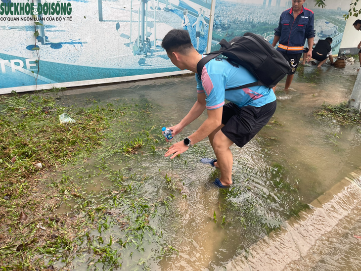 Người dân Hà Nội đua nhau bắt cá ở đường lớn sau trận mưa lớn - Ảnh 2.