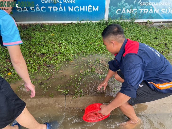 Người dân Hà Nội đua nhau bắt cá ở đường lớn sau trận mưa lớn - Ảnh 3.