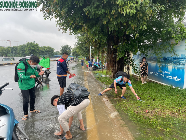 Người dân Hà Nội đua nhau bắt cá ở đường lớn sau trận mưa lớn - Ảnh 4.