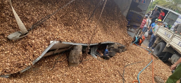 Xe tải chở dăm gỗ lật, đè chết 3 người - Ảnh 1. Xe tải chở dăm gỗ lật, đè chết 3 người - Ảnh 1.