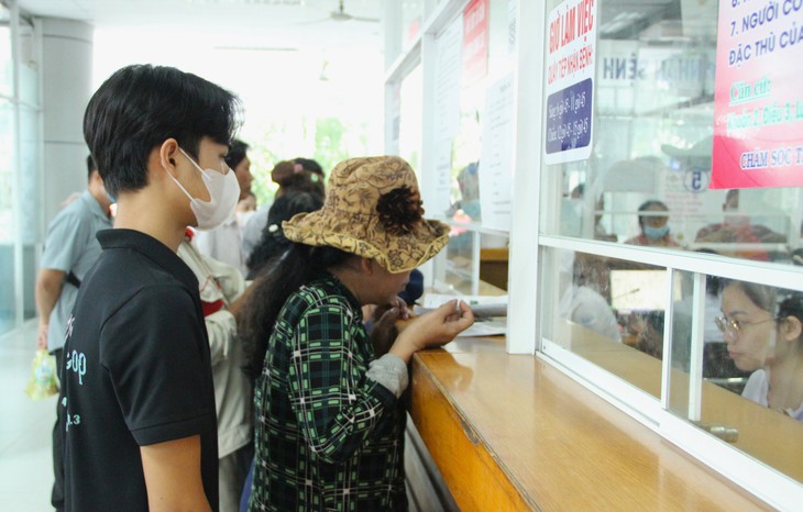 Nhân viên, y bác sĩ Bệnh viện huyện Bình Chánh luôn hỗ trợ, hướng dẫn tận tình cho người dân đến điều trị. Ảnh: Xuân Dự