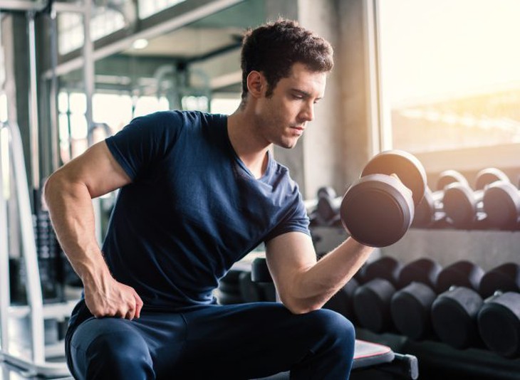 người đàn ông đang tập bài tập cô lập uốn cong bắp tay