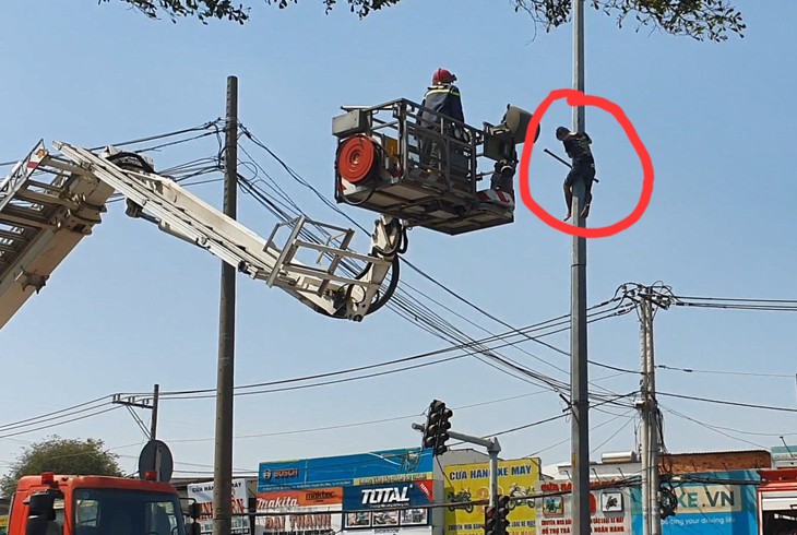 TPHCM: Giải cứu nam thanh niên trèo cột đèn cố thủ- Ảnh 1.