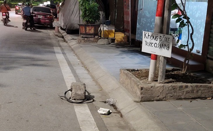 'Cắm mốc' chiếm lòng đường giành chỗ đỗ ô tô có vi phạm pháp luật không?- Ảnh 3.