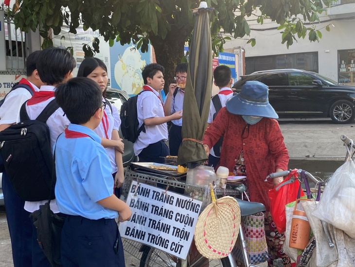 Nguy cơ ngộ độc từ hàng rong, quà vặt trước cổng trường ở TPHCM- Ảnh 1.