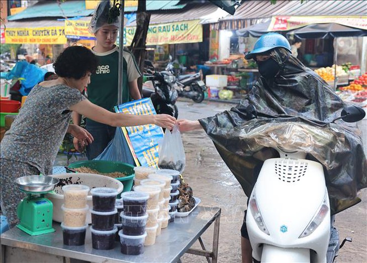 Người dân Hà Nội đội mưa đi mua sắm trong Tết Đoan Ngọ- Ảnh 4.