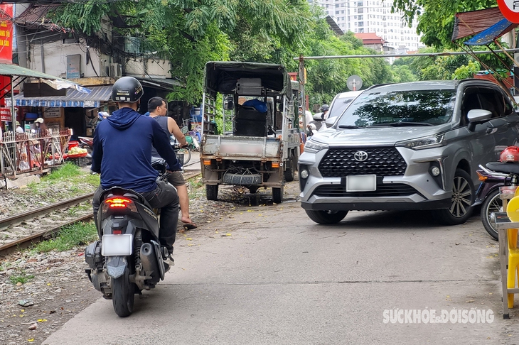 Người dân lấn chiếm hành lang an toàn đường sắt để... họp chợ, đỗ xe, trồng rau - Ảnh 1.