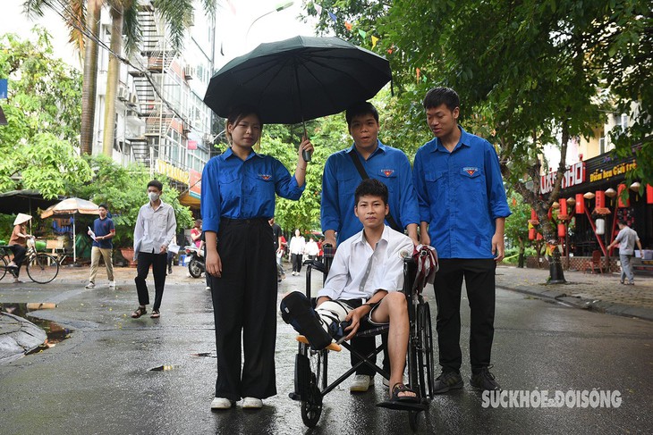 Hà Nội: Thí sinh bị gãy chân vừa mổ cấp cứu được sinh viên tình nguyện đưa vào phòng thi- Ảnh 2.