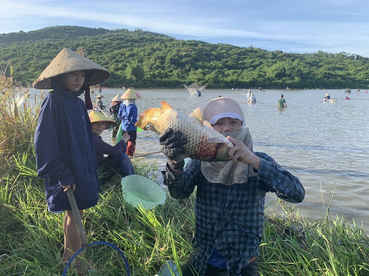 Sau tiếng trống, hàng nghìn người lao xuống đầm bắt cá cầu may- Ảnh 8.