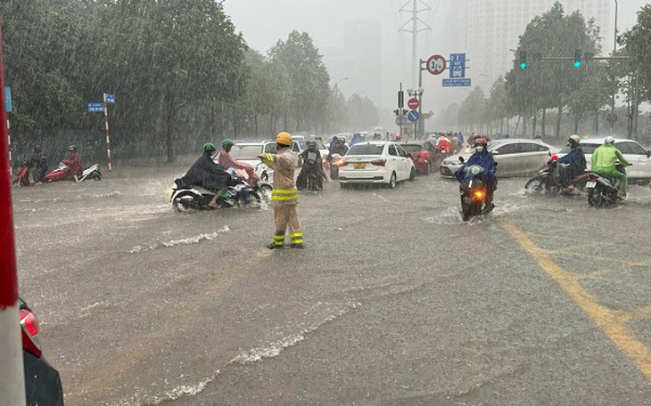 Sau trận mưa lớn, CSGT Hà Nội hướng dẫn người dân vượt ngập úng đến công sở