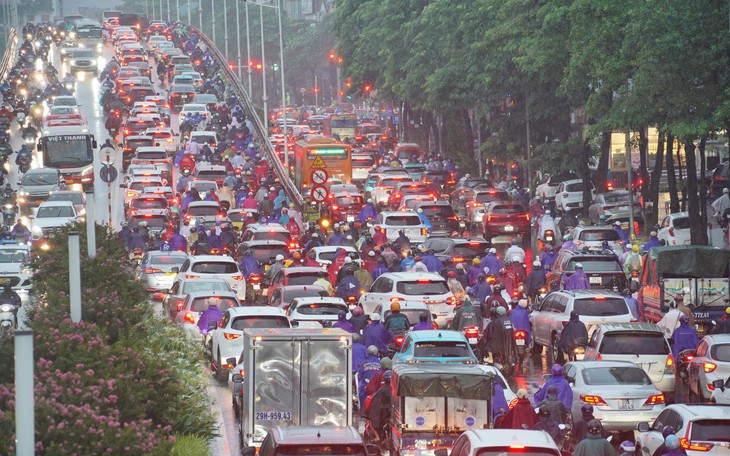 Ảnh: Người dân chật vật di chuyển trong cơn mưa kéo dài do ảnh hưởng bão số 2