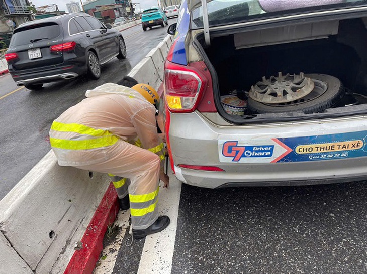 Hình ảnh đẹp về Đại úy CSGT hỗ trợ thay lốp cho xe taxi trong ngày mưa- Ảnh 1. Hình ảnh đẹp về Đại úy CSGT hỗ trợ thay lốp cho xe taxi trong ngày mưa- Ảnh 1.