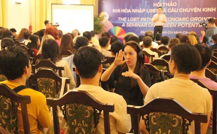 Thể hiện nội dung bằng ngôn ngữ ký hiệu cho đại biểu khiếm thính tham dự hội thảo. Ảnh: Xuân Dự